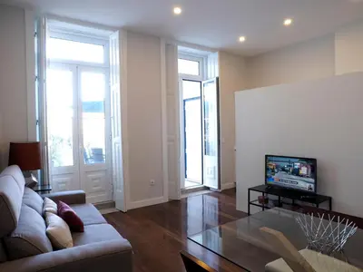 a living room with a couch and a tv at Cool Terrace Apartment in Porto