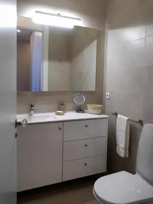 a bathroom with a white sink and a mirror at Cool Terrace Apartment in Porto