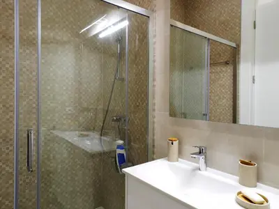 a bathroom with a sink and a glass shower at Cool Terrace Apartment in Porto