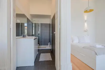 a bathroom with a bed and a shower and a sink at Downtown Spacious Studio in Porto