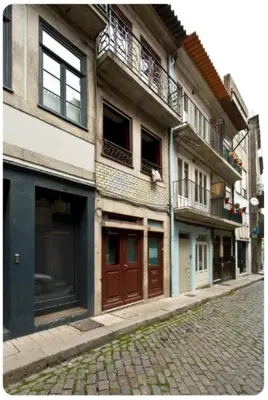 a building with balconies on a brick street at Porto Village Inn in Porto