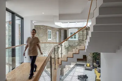 a woman walking down a staircase in a house at Caléway Hotel in Vila Nova de Gaia