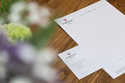 two white cards sitting on a table with flowers at Caléway Hotel in Vila Nova de Gaia