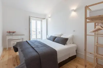 a white bedroom with a bed and a ladder at Oporto City View - Wonderful Apartment in Porto