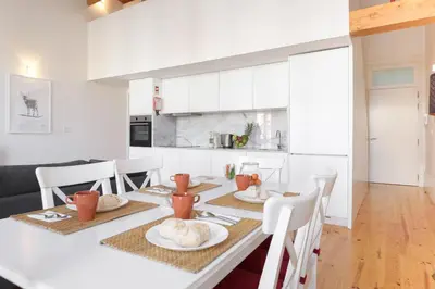 a kitchen and dining room with a table and chairs at Skylight Apartment in Porto