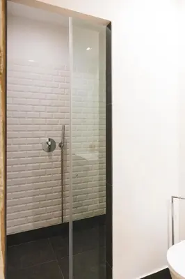 a shower with a glass door in a bathroom at Aposentus - Your fabulous home next to Ribeira in Porto