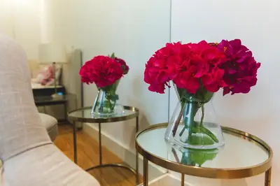 two vases with red flowers sitting on a glass table at Aposentus - Your fabulous home next to Ribeira in Porto