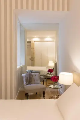 a bedroom with a bed and a chair and a mirror at Aposentus - Your fabulous home next to Ribeira in Porto