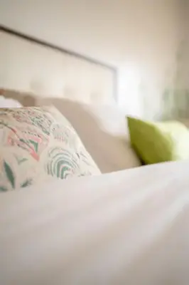 a white bed with a pillow on top of it at Apartamento Praça - Vistas sobre a cidade in Porto