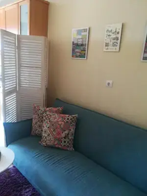a white wall with three paintings and a table at Apartamento Praça - Vistas sobre a cidade in Porto
