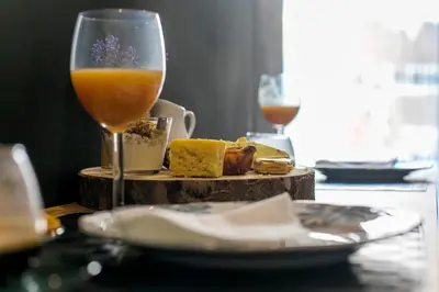 a table with a glass of wine and a plate of food at Chillout Trindade Apartment in Porto