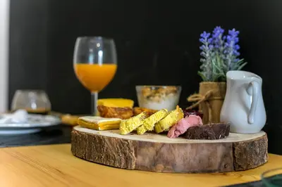 a table with a plate of food and a glass of wine at Chillout Trindade Apartment in Porto