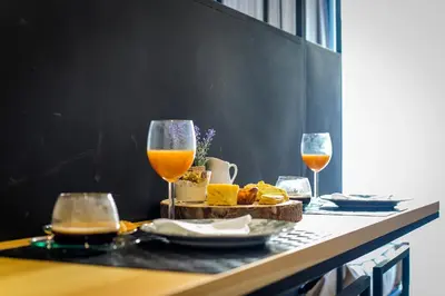 a table with two glasses of orange juice and bread at Chillout Trindade Apartment in Porto