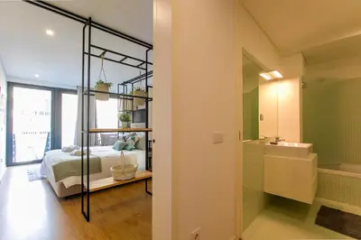 a bedroom with a bed and a bathroom at Chillout Trindade Apartment in Porto