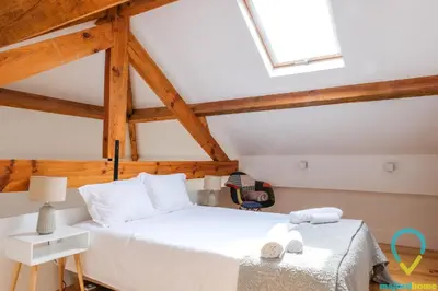 a bedroom with a white bed and a skylight at Loft Almada in Porto