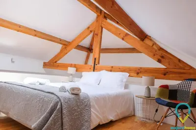 a bedroom with a bed and a wooden ceiling at Loft Almada in Porto