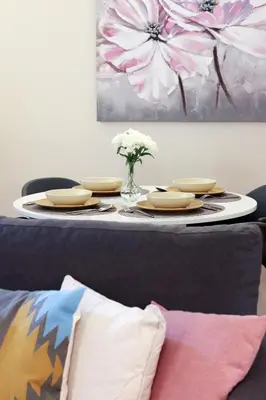 a table with plates and a vase of flowers on it at HM - Ribeira São João 1B in Porto