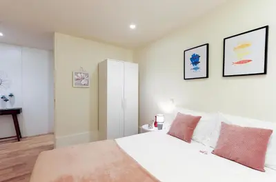 a bedroom with a white bed with two pink pillows at HM - Ribeira São João 1B in Porto