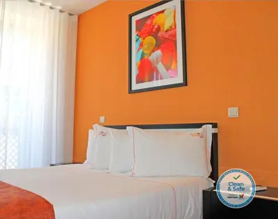 a bedroom with orange walls and a bed with white pillows at Vivacity Porto - Rooms & Apartments in Porto