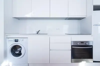 a white kitchen with a washing machine and a stove at ON Apartments - Violin in Porto