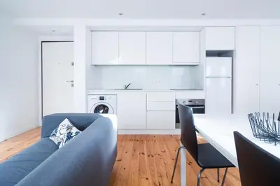 a living room with a blue couch and a kitchen at ON Apartments - Violin in Porto
