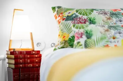 a bed with a pillow and a stack of books at Formosa Apartment with Free Parking and Historic Charm! in Porto