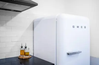 a white refrigerator in a kitchen with two drinks on a counter at Formosa Apartment with Free Parking and Historic Charm! in Porto