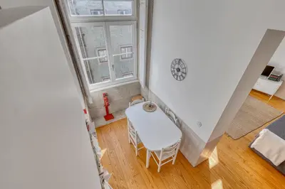 an attic room with a chair and a window at Formosa Apartment with Free Parking and Historic Charm! in Porto
