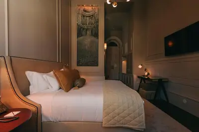 a bedroom with a bed and a desk with a television on the wall at Torel 1884 Suites & Apartments in Porto
