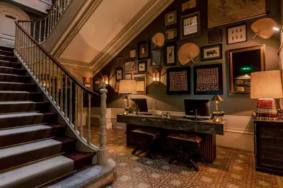 a room with a staircase with a desk and a piano at Torel 1884 Suites & Apartments in Porto