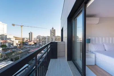 a balcony with a couch and a view of the city at LovelyStay - Trindade Cozy Apartment in Porto