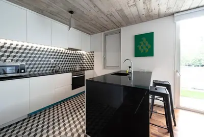 a kitchen with white cabinets and a black counter top at PortoSoul Trindade in Porto