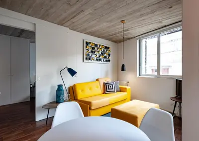 a living room with a yellow couch and a table at PortoSoul Trindade in Porto
