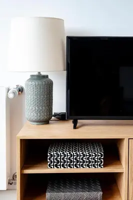 a table with a lamp and a tv on a shelf at PortoSoul Trindade in Porto