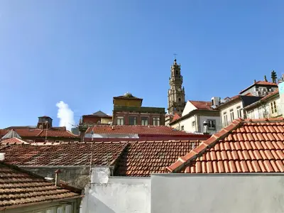 a view of roofs of a city with a clock tower at Lóios Flat in Porto