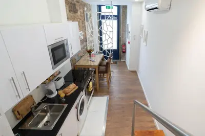 a kitchen with a sink and a stove top oven at Central Apartamento 0 AC Metro Nearby in Porto