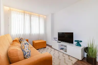 a living room with a couch and a flat screen tv at Ceuta Inn Porto in Porto