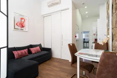 a living room with a black couch and a table at Central Cozy Star 1 Balcony AC Near Merto in Porto