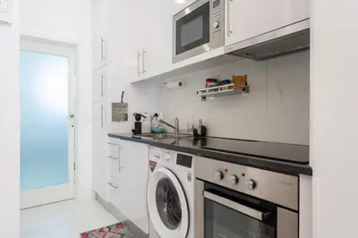 a kitchen with a washing machine and a microwave at Central Cozy Stay 2 AC Near Metro in Porto