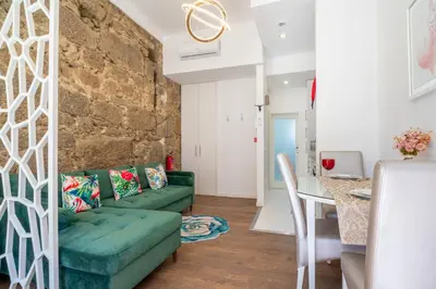 a living room with a green couch and a table at Central Cozy Stay 2 AC Near Metro in Porto