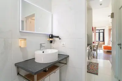 a white bathroom with a sink and a mirror at Central Cozy Stay 2 AC Near Metro in Porto