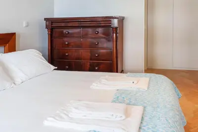 a bedroom with a dresser and two towels on a bed at Go2oporto @Ceuta in Porto