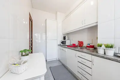 a white kitchen with white cabinets and a sink at GuestReady - Sweet & Relax Flat in Porto