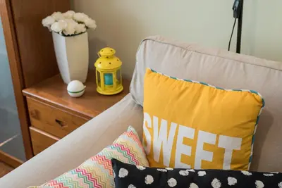 a couch with two pillows and a vase of flowers at GuestReady - Sweet & Relax Flat in Porto