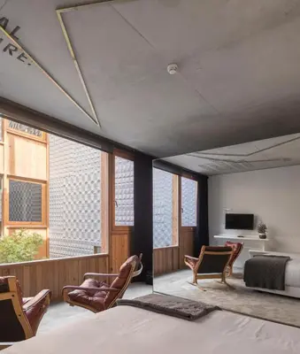 a bedroom with a bed and chairs and a tv at Hotel Tipografia do Conto by Casa do Conto in Porto