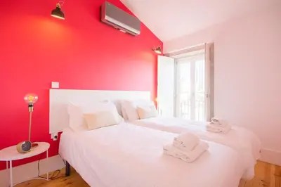 a red room with a bed with towels on it at Loft D. João IV in Porto