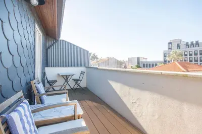 a balcony with chairs and a table on a building at Loft D. João IV in Porto
