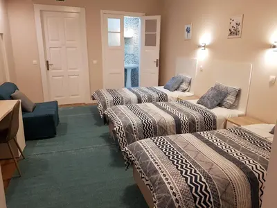 a hotel room with three beds and a couch at HaoBo Porto Center in Porto