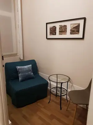 a living room with a blue couch and a table at HaoBo Porto Center in Porto
