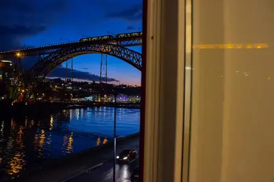 a window with a view of a harbor and a bridge at Red House By The River in Porto